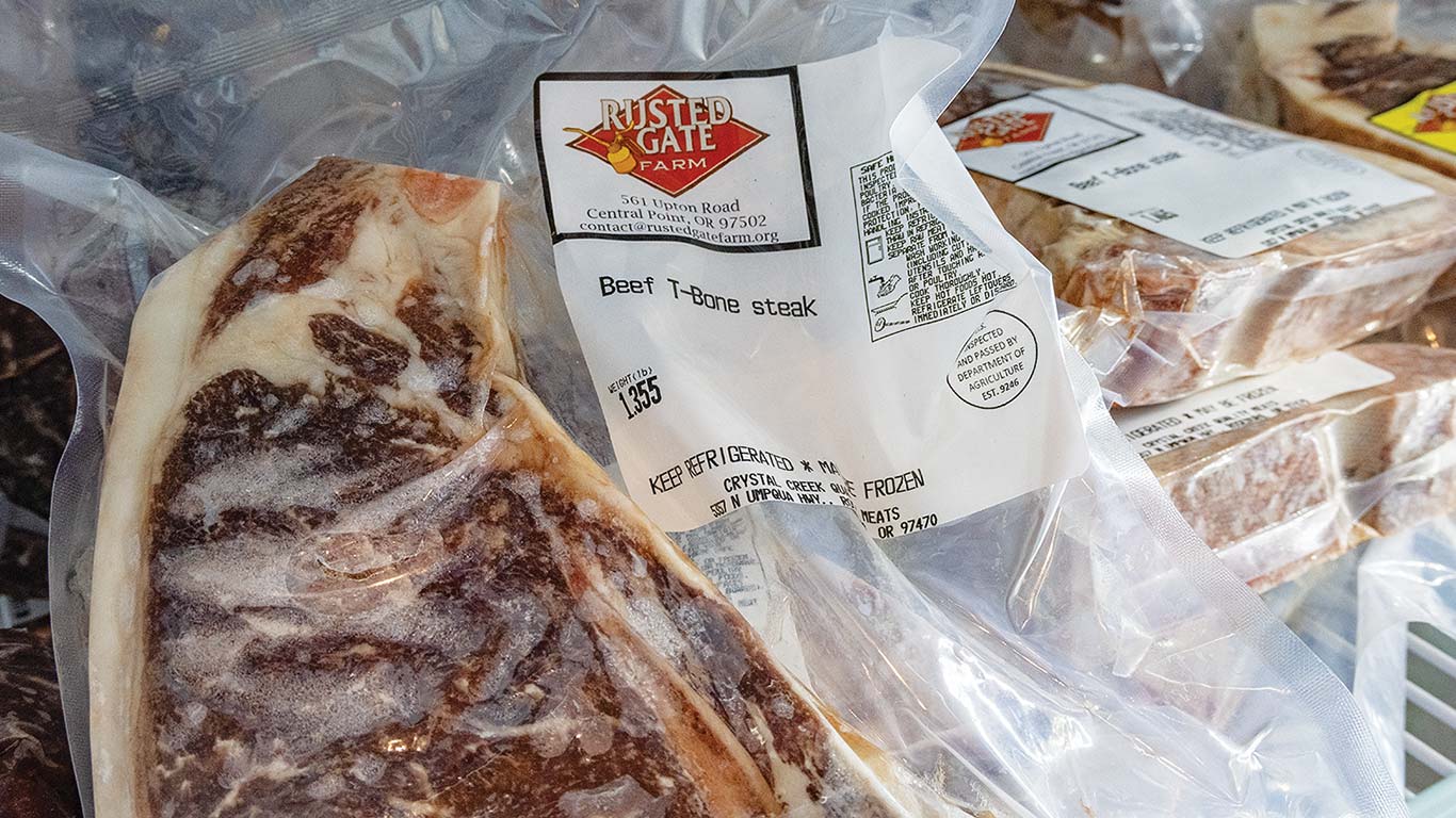 Vacuum-sealed T-bone steak labeled Rusted Gate Farm in a freezer.