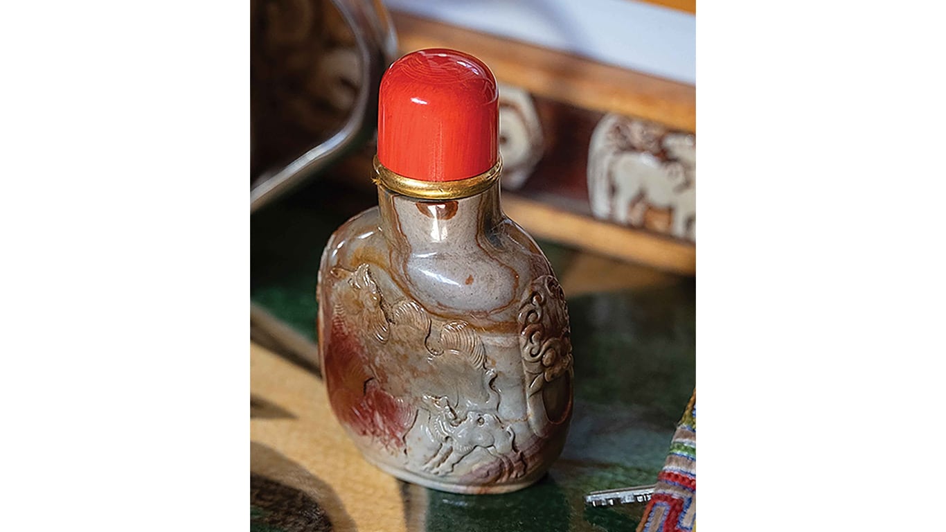 Close-up of a carved decorative bottle with a red cap.