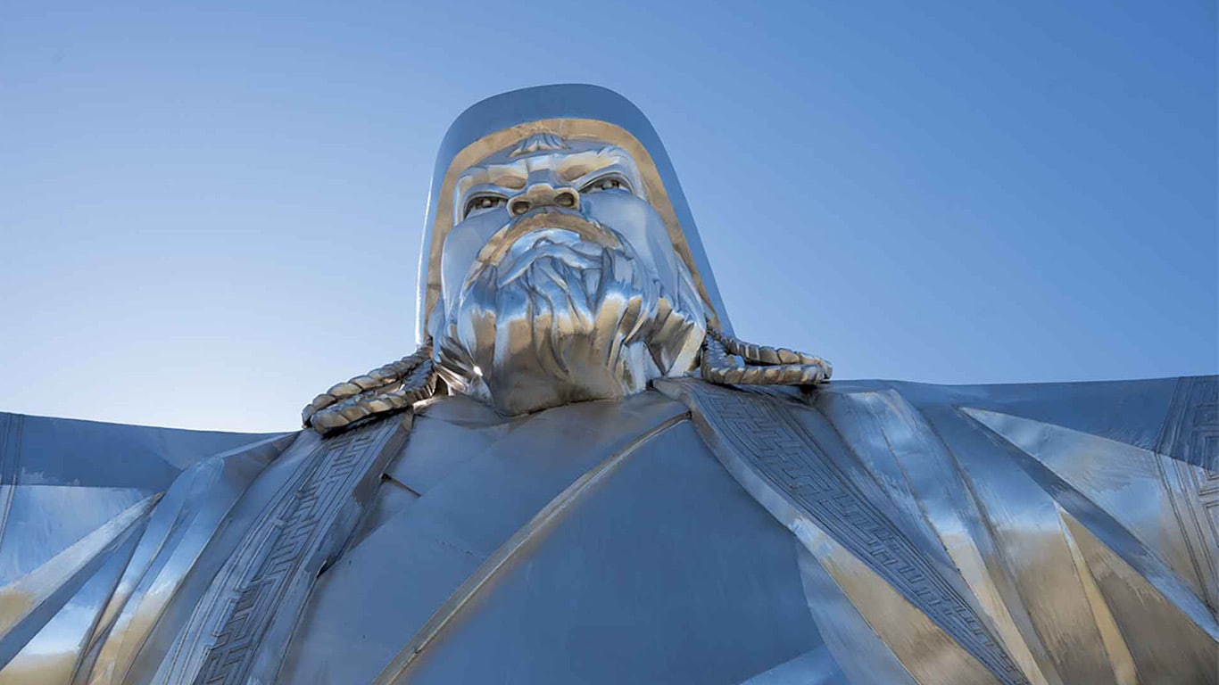 Low-angle view of a large metallic statue under a clear sky.