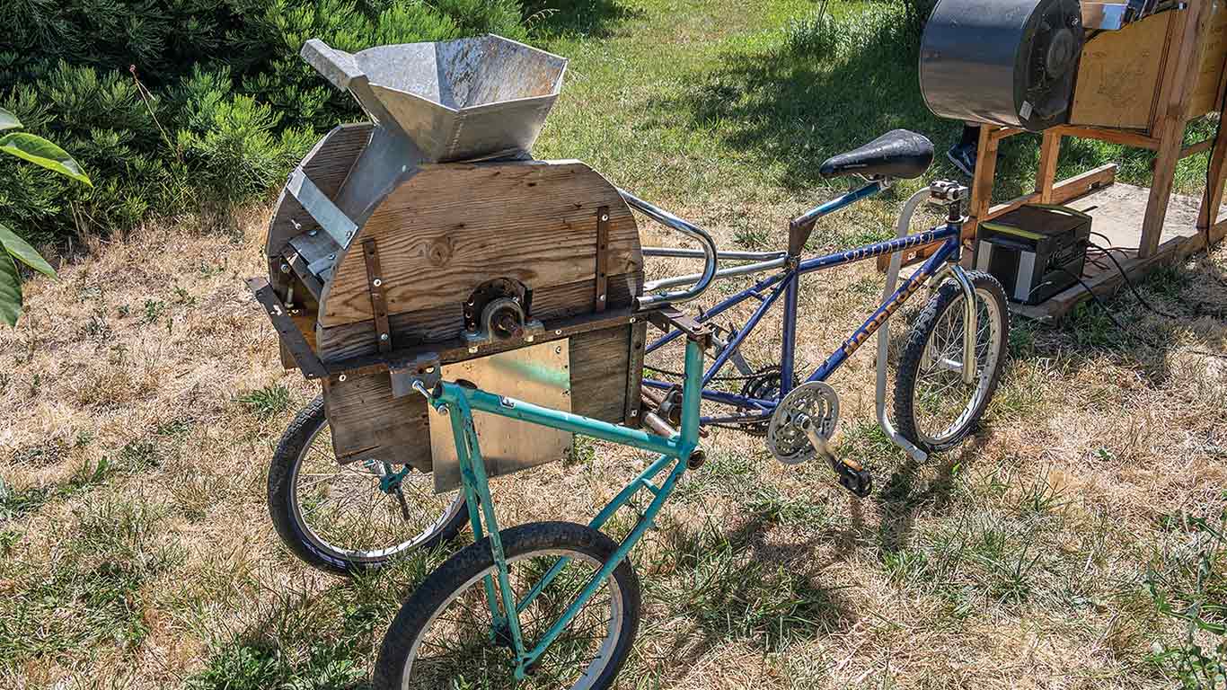 Farm equipment mounted on a modified bicycle.