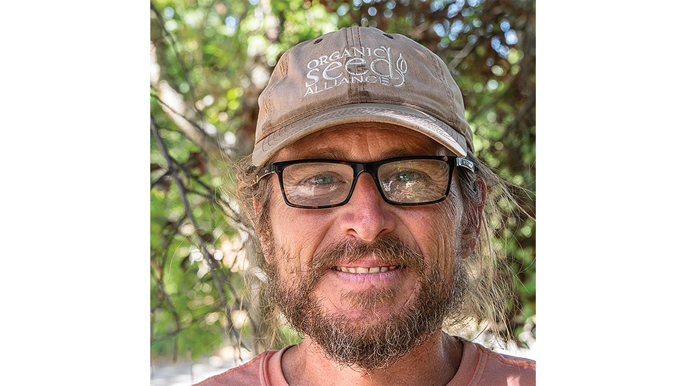 Close-up of a person wearing glasses and a cap outdoors.