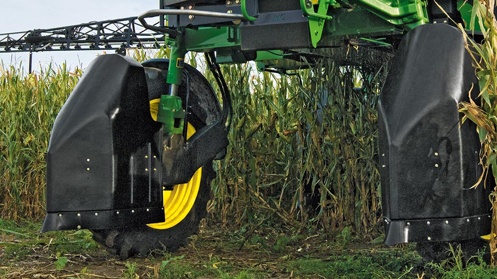 John Deere wheel shields parting crops for sprayer pass through.